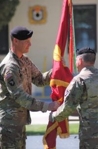 LTC Dustin G. Bishop accepting the flag from COL James L. Brown.